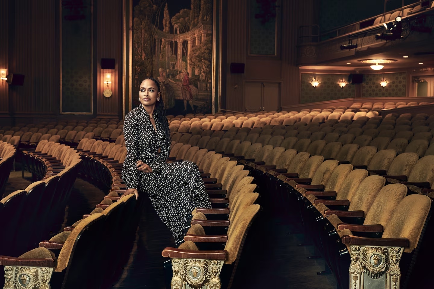 Ava DuVernay sits in an ornate theater, promoting her film 'Origin'.