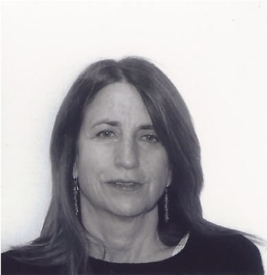 Doro Bachrach portrait, head and shoulders shot with long hair and earrings.
