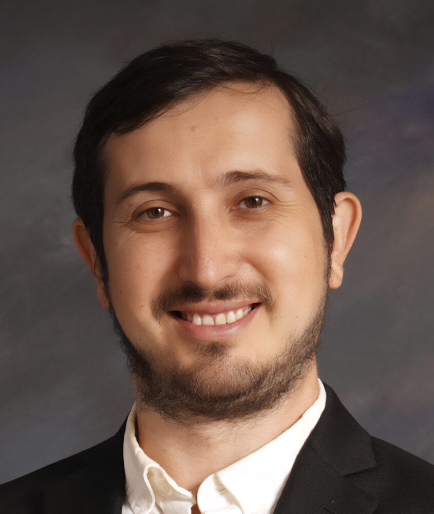 Igor Shteyrenberg headshot, smiling with a beard, wearing a suit and white shirt.