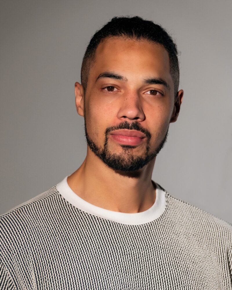 Portrait of Jai Jamison wearing a striped shirt.
