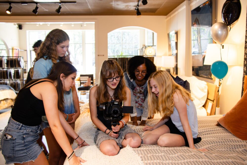 Students filming with a camera on a bed at Light House Studio Shorts.