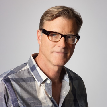 John Lee Hancock in a blue plaid shirt and glasses