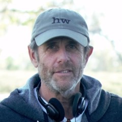 Marc Abraham wearing a hat and headphones outdoors.