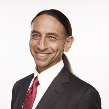 Scot Safon in suit smiling at camera