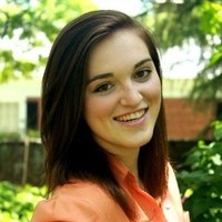 Lizzy Ramey, a smiling woman with brown hair, outdoors.