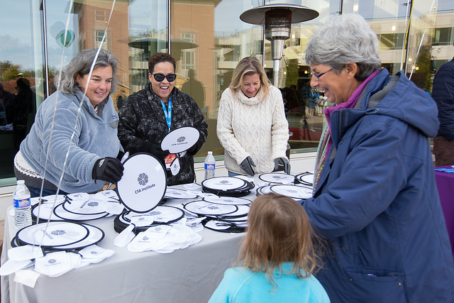 Volunteers at CFA Institute corporate sponsorship event give away swag.