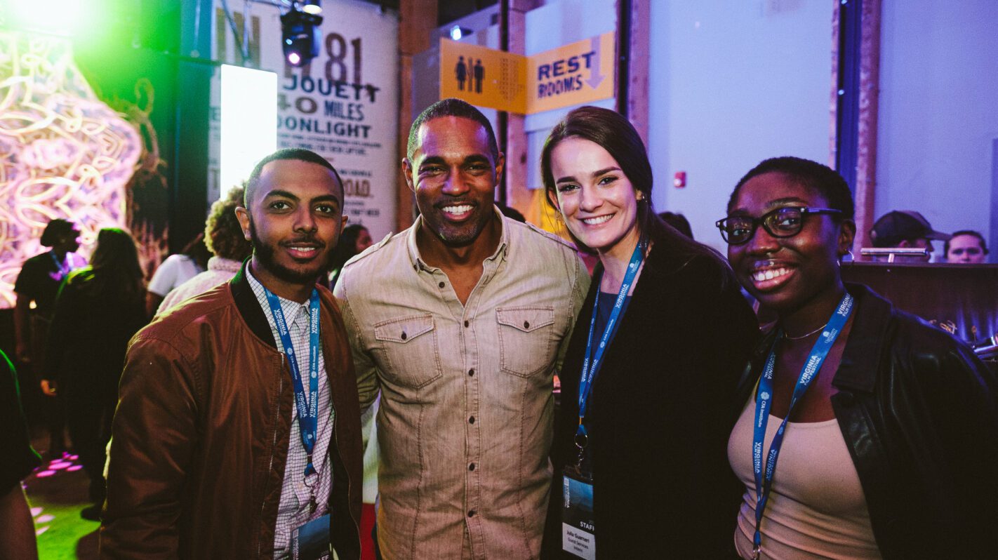 Group of diverse professionals at a Jobs fair, smiling at the camera.