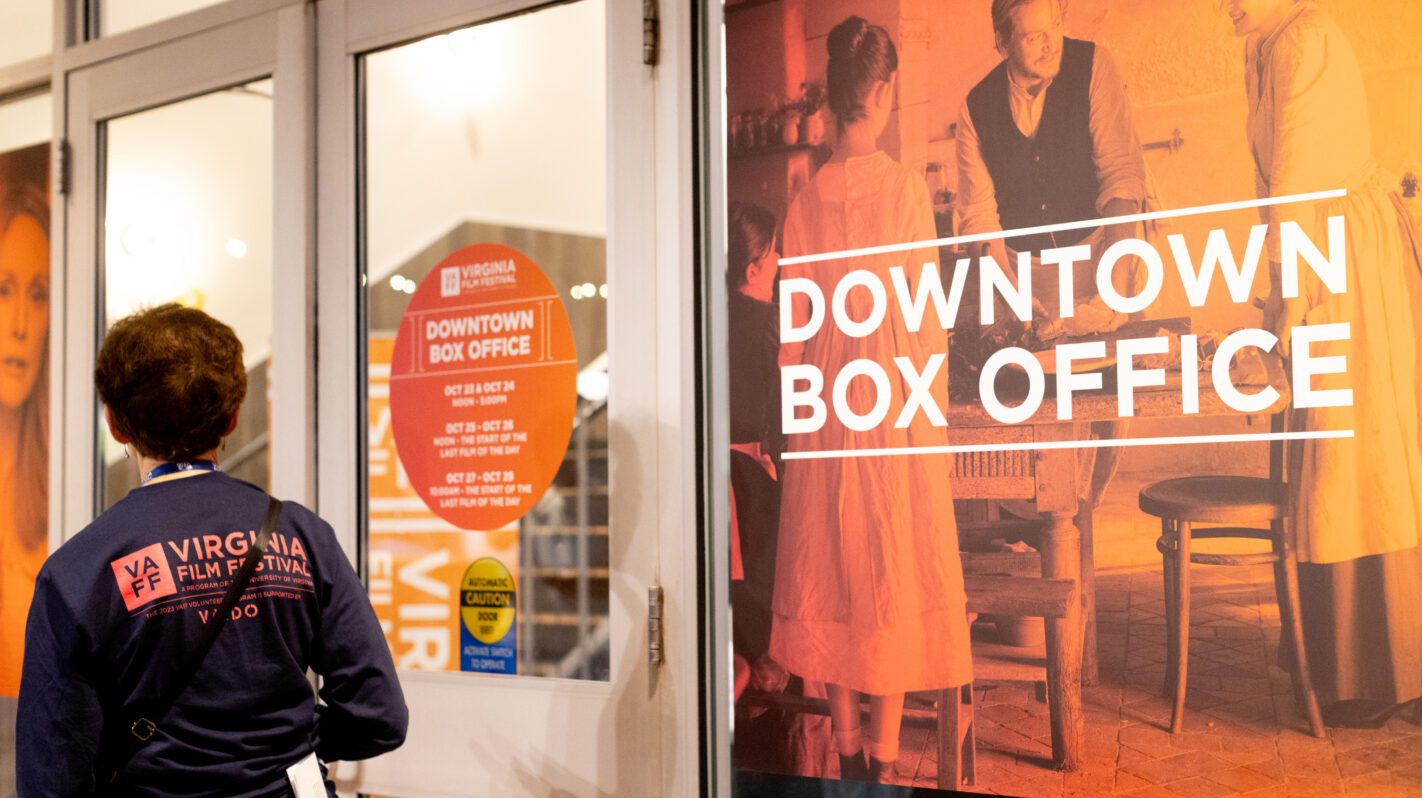 Virginia Film Festival's downtown box office, with a woman approaching the entrance. "Downtown Box Office" text visible.