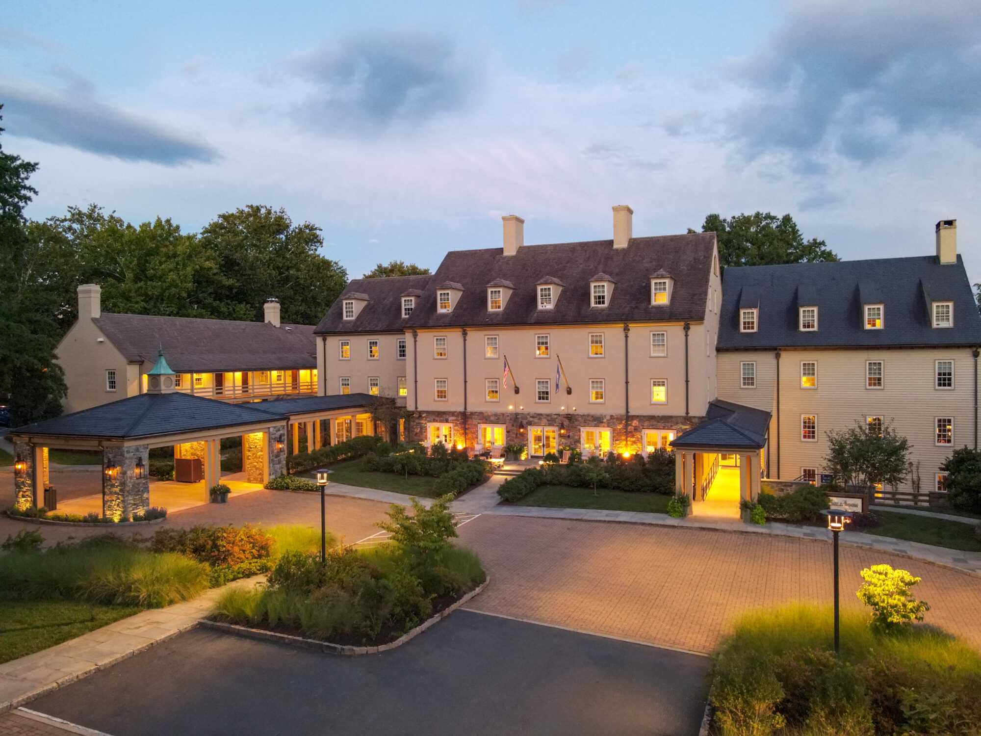 Luxury hotel entrance at dusk with illuminated walkway.