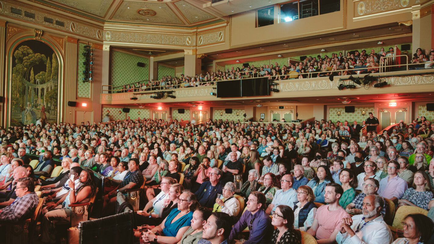Full theater audience, possibly attending a venue event.