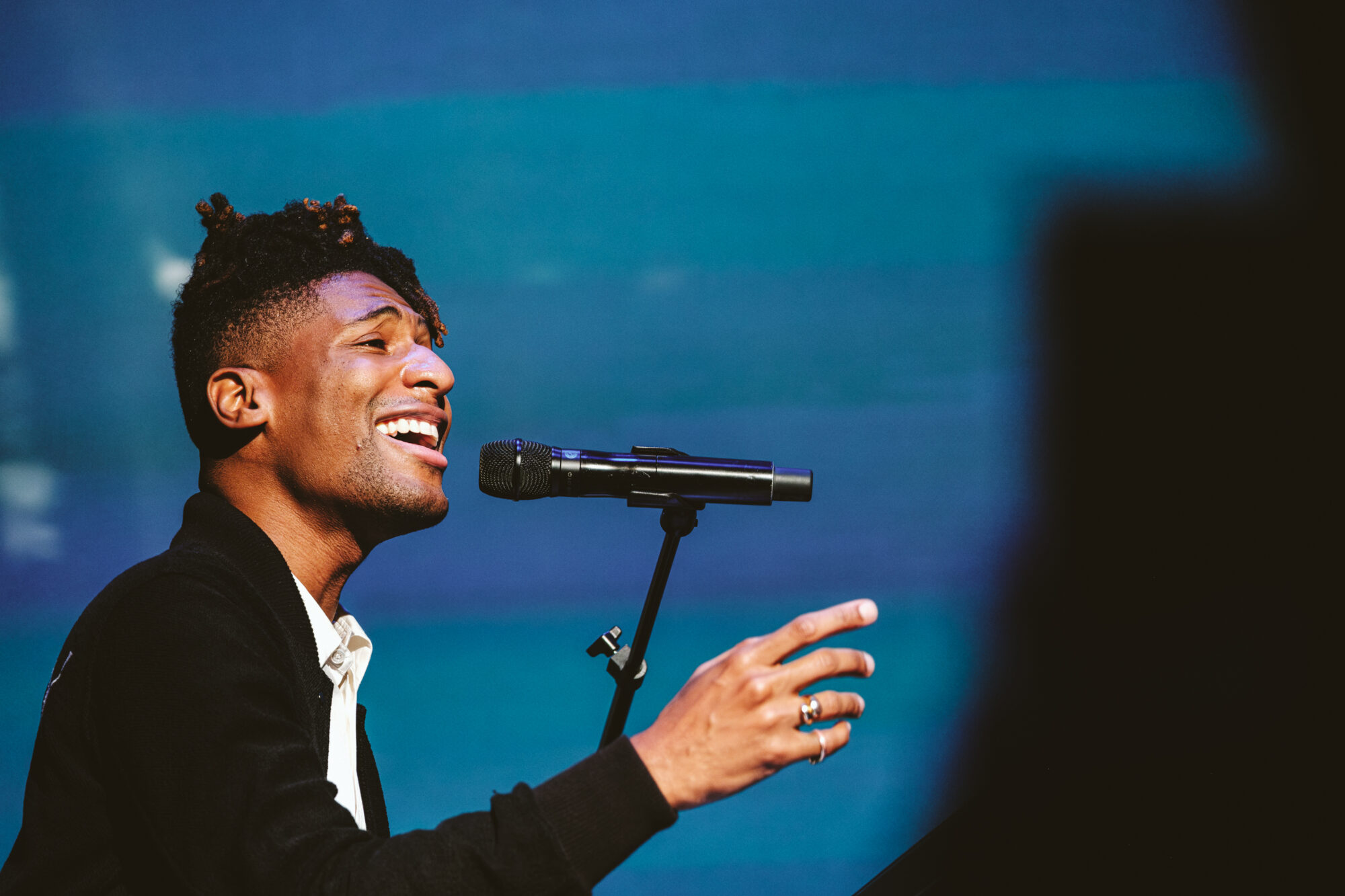 Singer with microphone on stage, performing with passion.