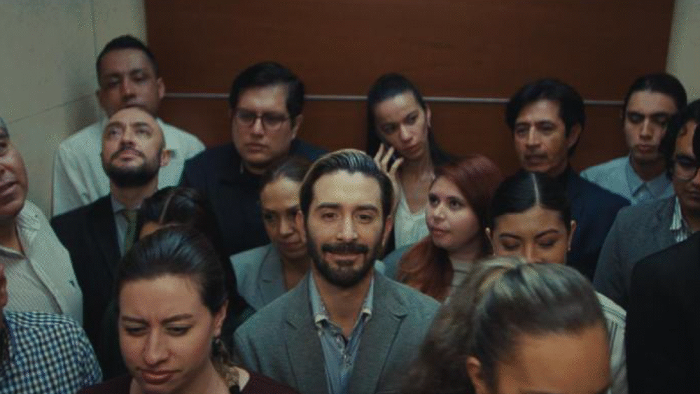 Crowded elevator with diverse people, some looking somber.