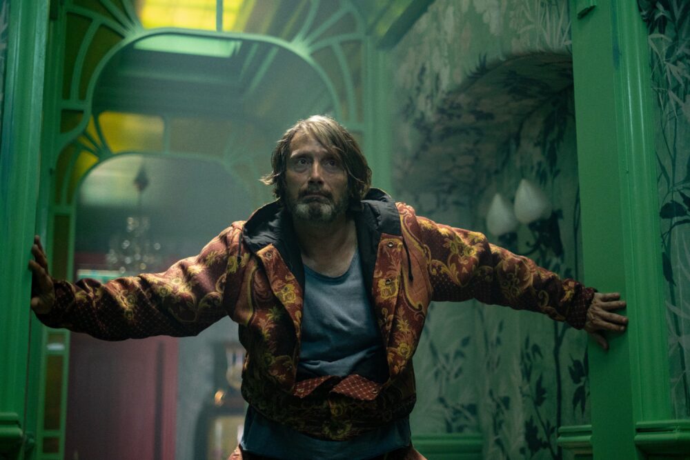 Mads Mikkelsen in "Dust Bunny" with arms outstretched.