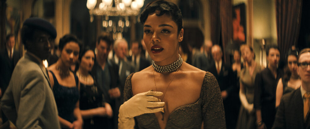 Tessa Thompson as Hedda in a dramatic scene with a crowd.