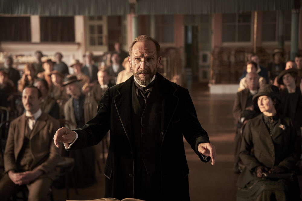 Ralph Fiennes conducting a choir in "The Choral