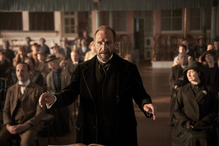Ralph Fiennes conducting a choir in "The Choral