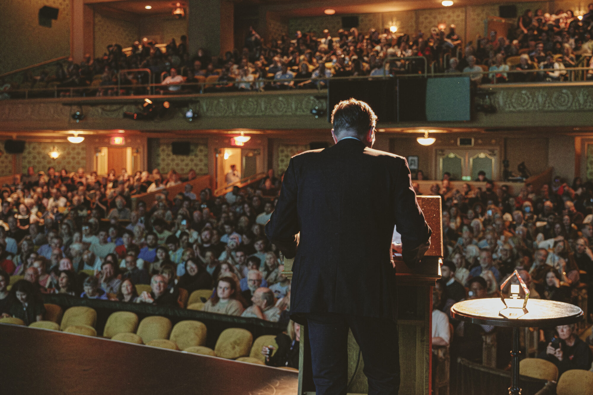 Speaker addressing a large audience in a theater, 2025 Donors event.