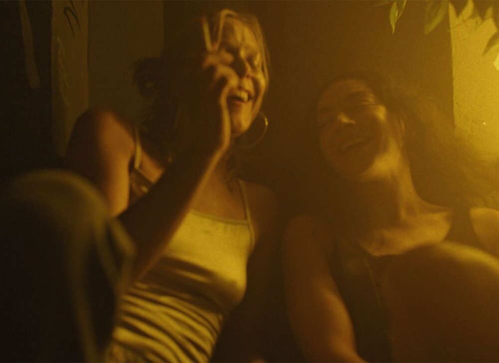 Two friends laughing in warm, golden light.