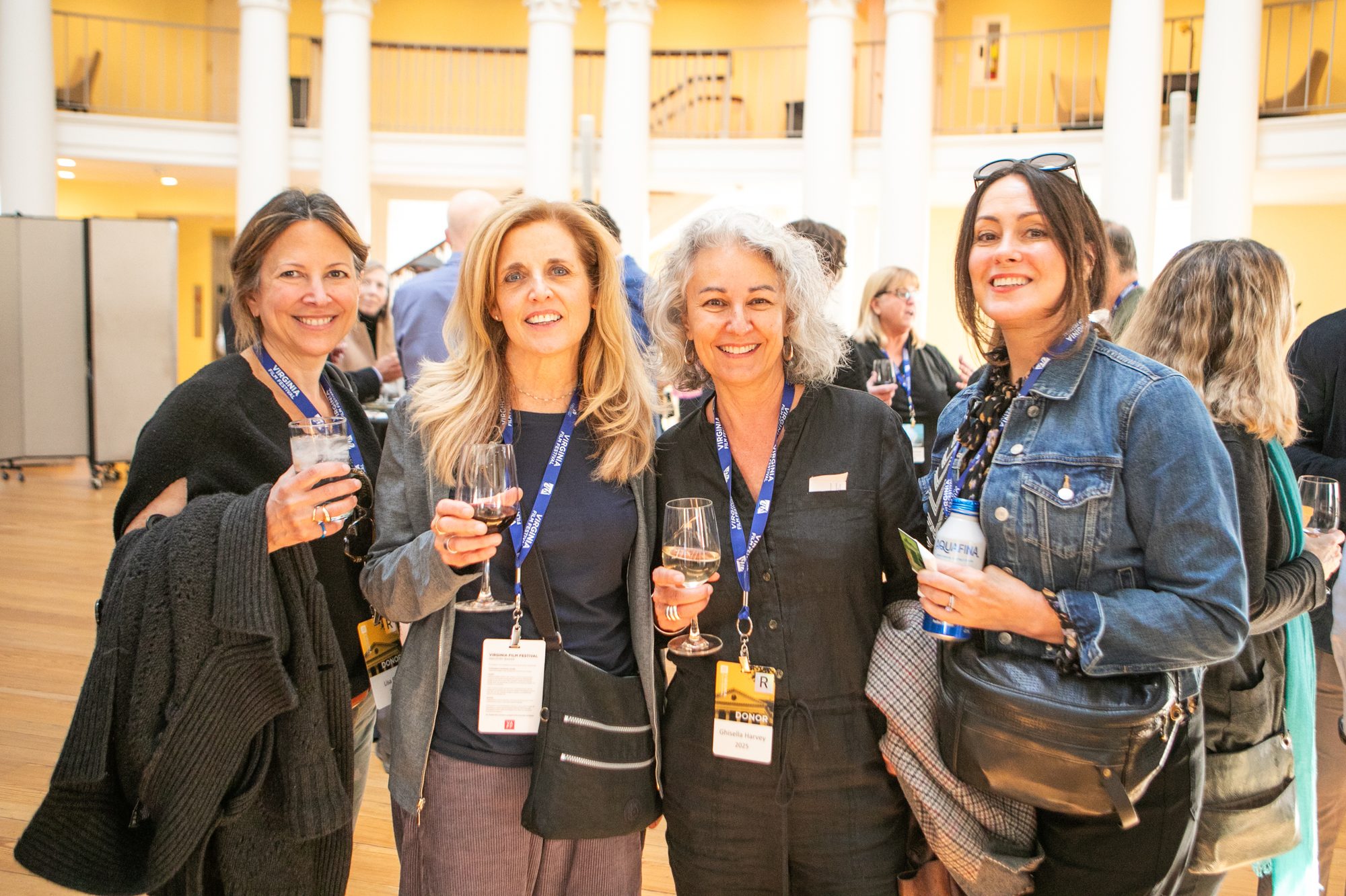 Four women smiling and holding drinks at a 2026 Donors event.